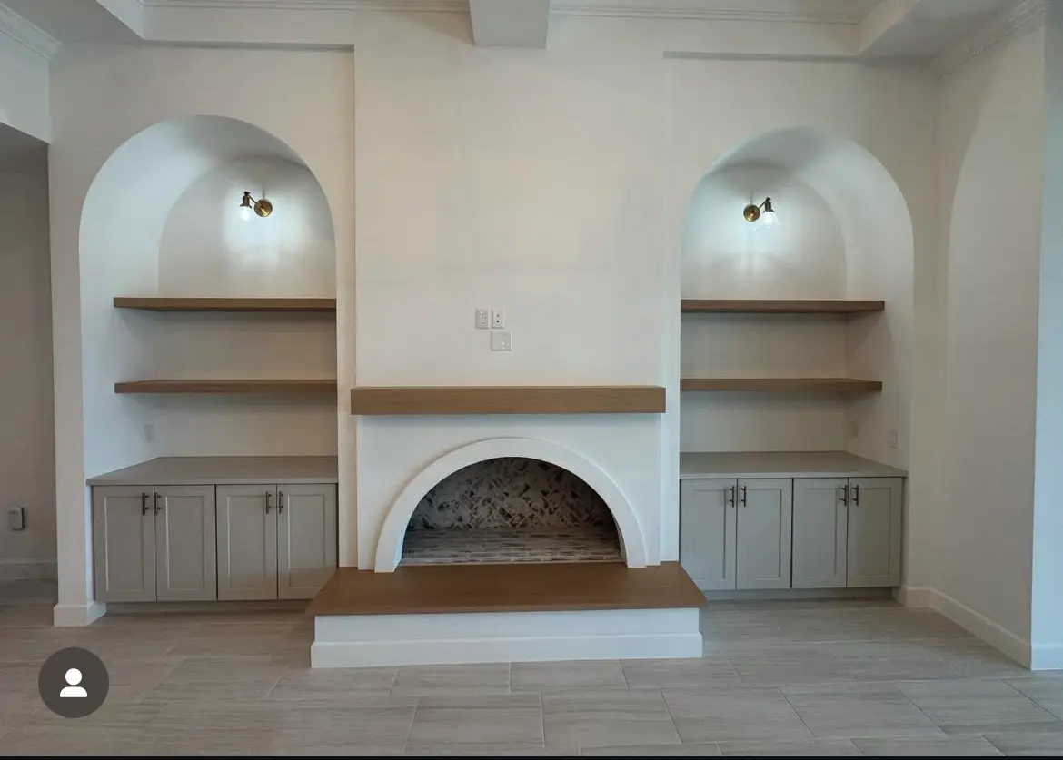 Custom arched fireplace feature with built-in cabinets, shelves and lighting
