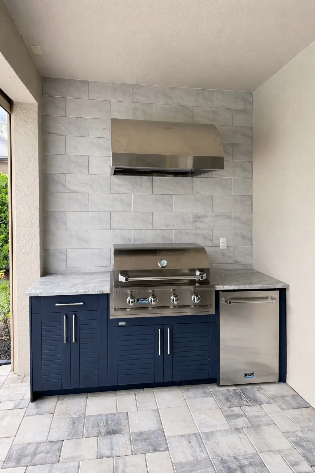 Blue WeatherStrong cabinet outdoor kitchen with grill, refrigerator and tiled wall